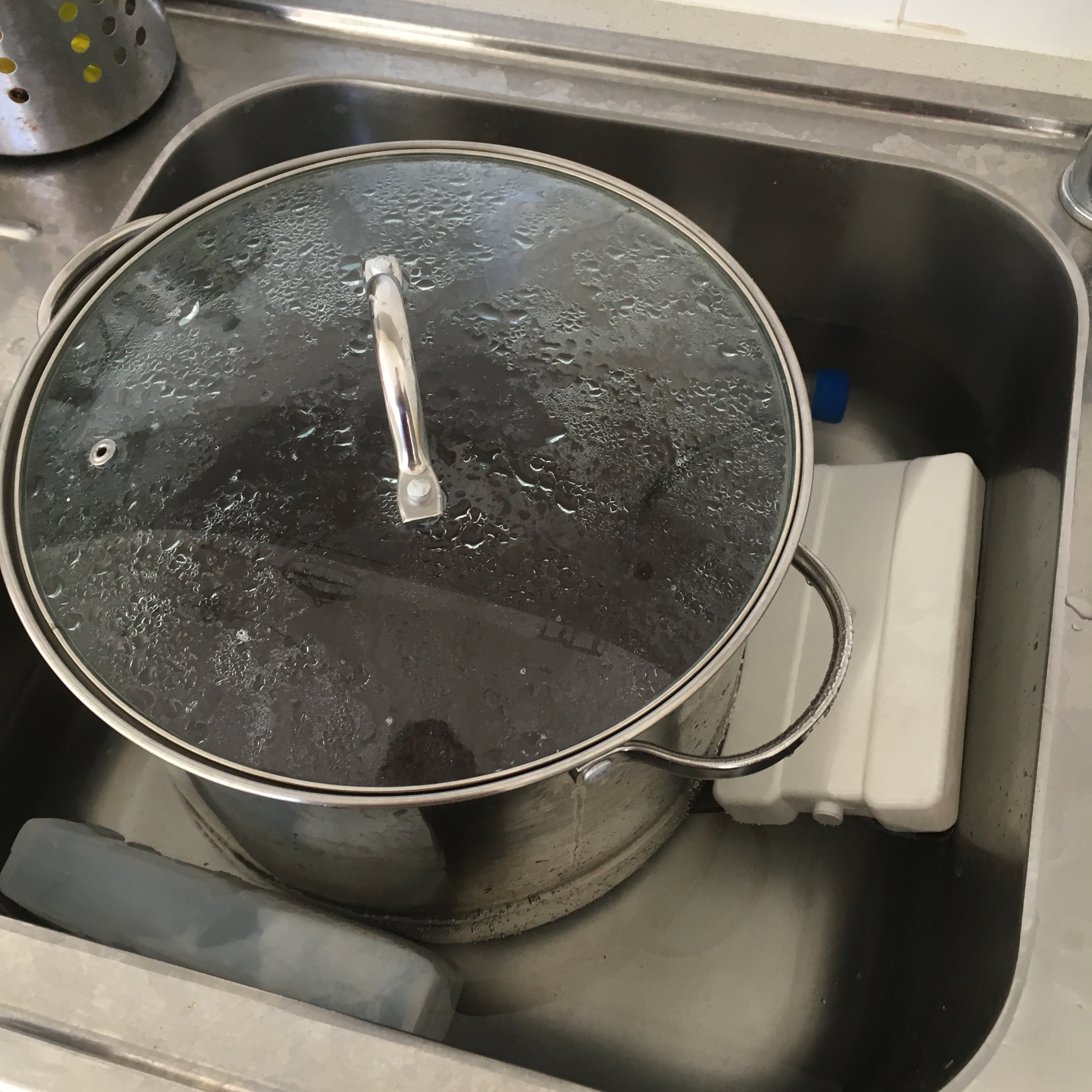 Put the pot in the sink to cool off. This can often take a few hours unless a lot of ice is added